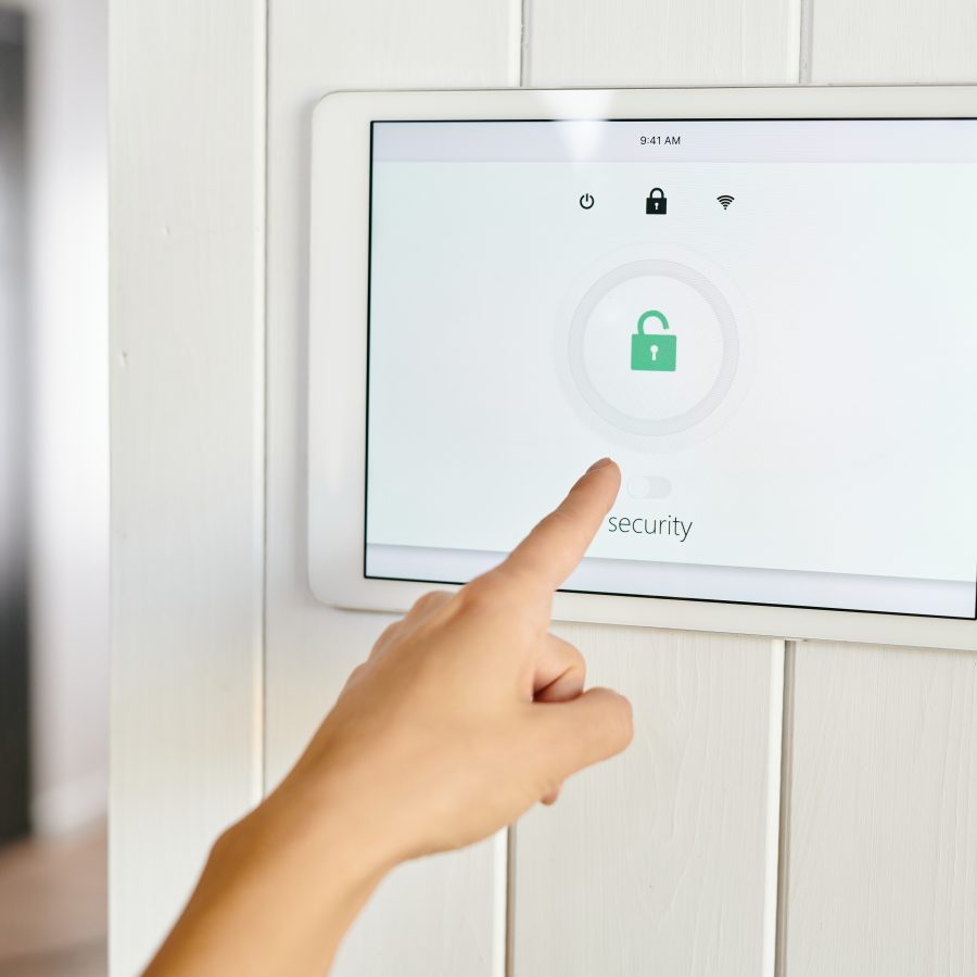A hand pointing at panel of home security appliance