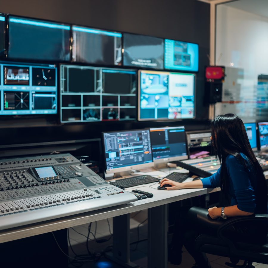 Middle aged woman using equipment in control room on a tv station Middle aged woman using equipment in control room on a tv station