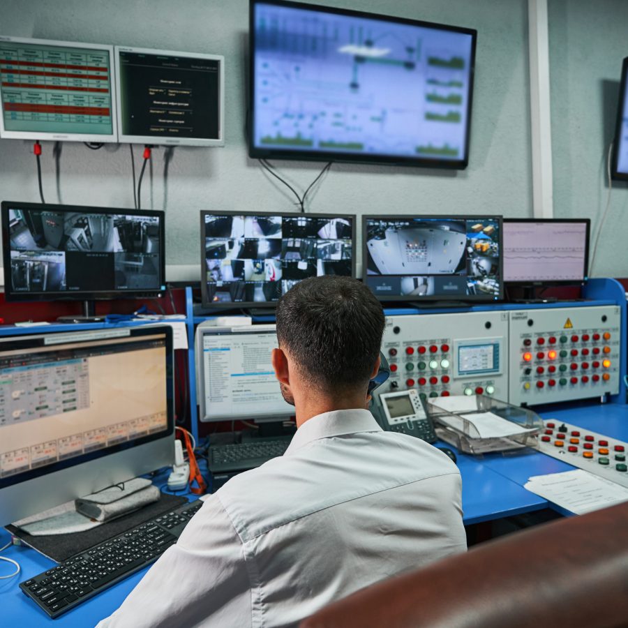 Server administrator looking after data center rooms through monitors